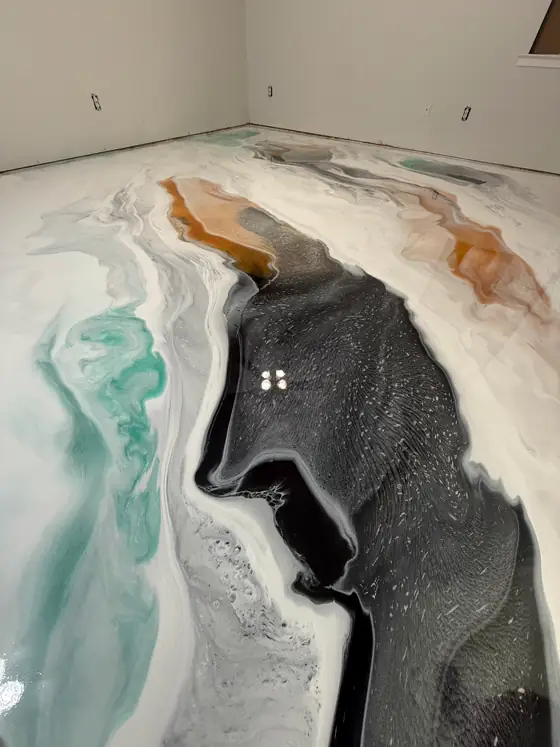 Teal and copper metallic resin curling around a deep black pool