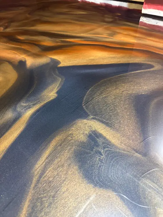 Gold metallic epoxy against deep navy in a room with maroon walls