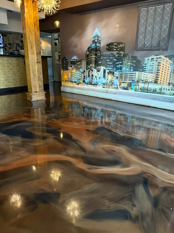 Copper and navy metallic floor running through a bar interior
