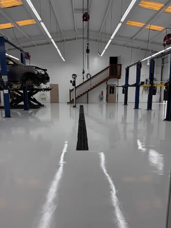 Long white epoxy shop bay with vehicle lifts
